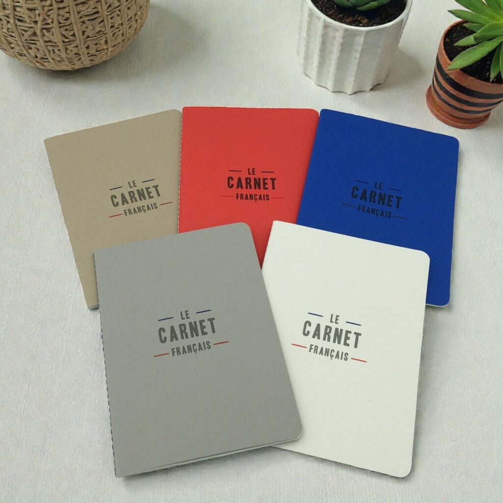 Carnets recyclés Les Parisiens de la marque Le Carnet Français d’Agoria, présentés en cinq couleurs : beige, rouge, bleu, gris et blanc.