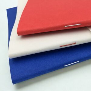 Gros plan sur la reliure agrafée à deux piques métal du carnet fabriqué en France Colégram