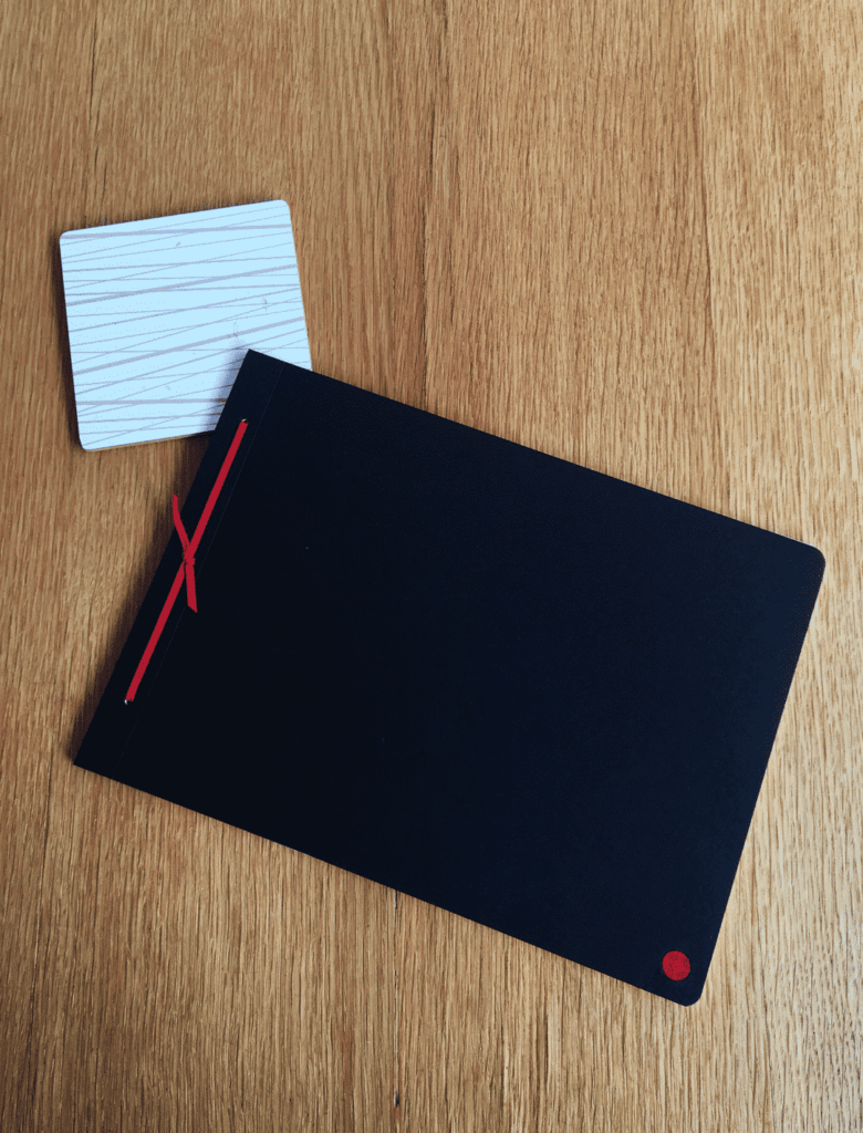 Journal de Justine, carnet fabriqué en France avec reliure en cuir rouge, posé fermé sur un bureau