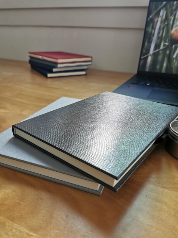 carnet luminis gris posé sur une table en bois