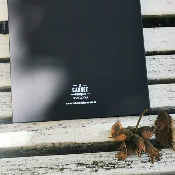 carnet noir sur banc blanc